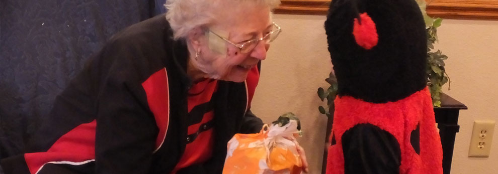 Older woman smiling at child dressed up for Halloween